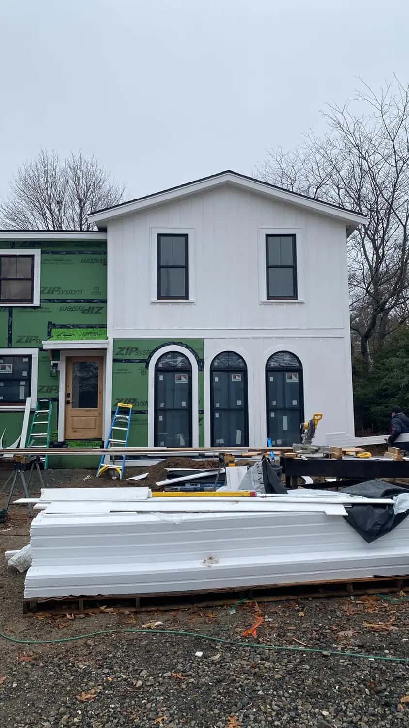 New white siding and three arched black windows on a home addition in Lynnfield, MA